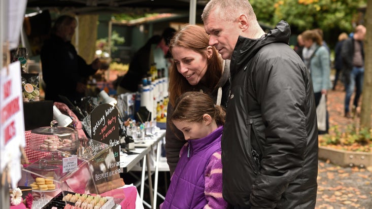 A man, a woman and a child browsing a stall at a Christmas market